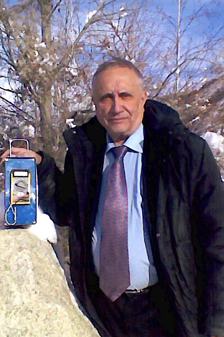 Виктор Михайлович Инюшин на зимнем снимке держит переносной прибор
